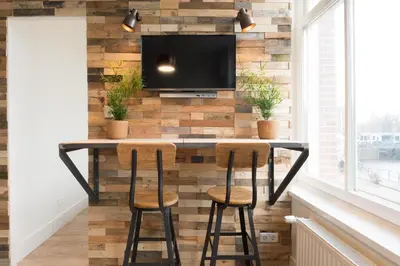 a bar in a room with a tv and stools at Happy Day´s in Amsterdam