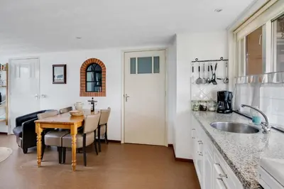 a kitchen with a table and a dining room at 't Zwanennest in Egmond aan den Hoef
