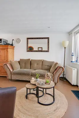 a living room with a couch and a table at 't Zwanennest in Egmond aan den Hoef