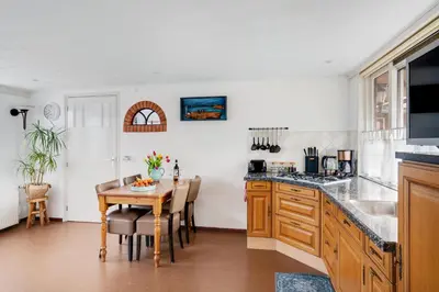 a kitchen with a table and a dining room at 't Zwanennest in Egmond aan den Hoef