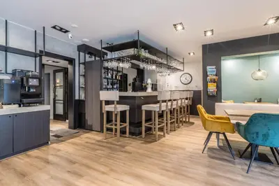 a kitchen with a bar with stools at Hotel Zee Bergen in Bergen