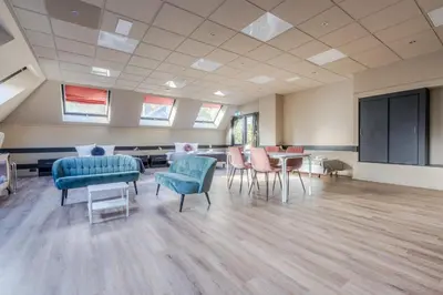 a large room with chairs and tables and a screen at Hotel Zee Bergen in Bergen