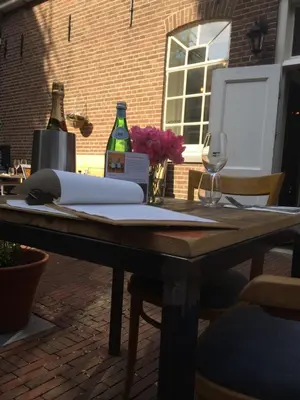 a wooden table with two bottles of wine on it at Proeverij de Azijnmakerij in Zeist
