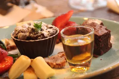 a plate of food with a chocolate muffin and fruit at Proeverij de Azijnmakerij in Zeist