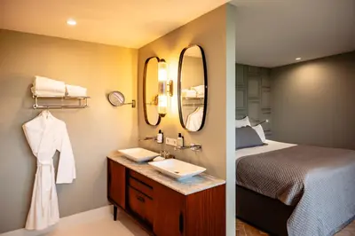 two pictures of a bathroom with a bed and a sink at Boutique Hotel De Witte Dame in Abcoude