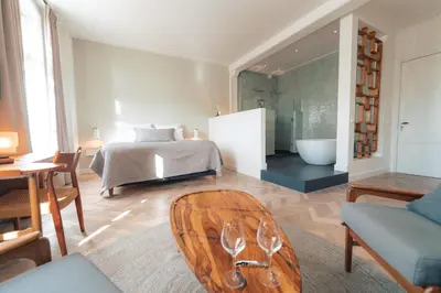 a living room with a bed and a chair at Boutique Hotel De Witte Dame in Abcoude