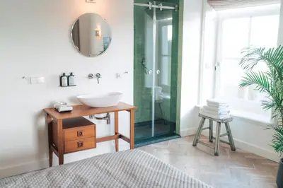a bathroom with a sink and a glass shower at Boutique Hotel De Witte Dame in Abcoude