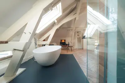 a bathroom with a white bath tub sitting on a black counter at Boutique Hotel De Witte Dame in Abcoude