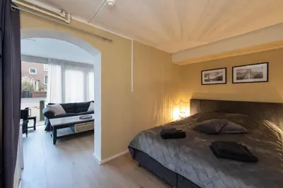 a bedroom with a bed and a living room at Blankebil Studios & Apartments in Zandvoort