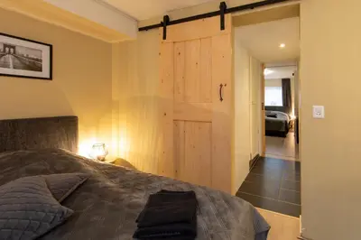 a bedroom with a bed and a sliding barn door at Blankebil Studios & Apartments in Zandvoort