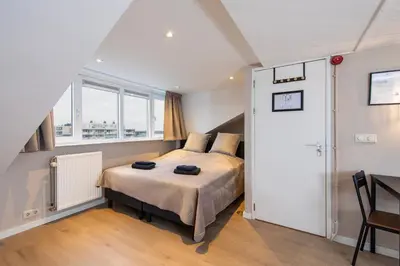 a bedroom with a bed and a window at Blankebil Studios & Apartments in Zandvoort