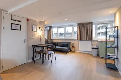 a living room with a table and chairs and a couch at Blankebil Studios & Apartments in Zandvoort