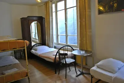a room with two bunk beds and a table and a window at Hotel Tamara in Amsterdam