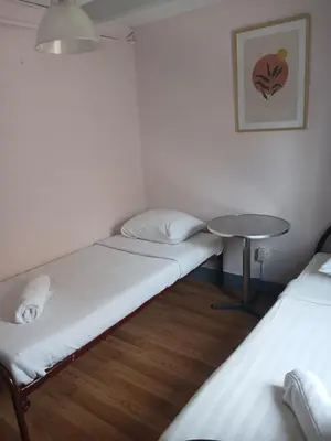 a small room with two beds and a table at Hotel Tamara in Amsterdam