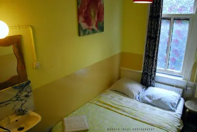 a small room with a bed and a window at Hotel Tamara in Amsterdam