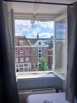 a bedroom window with a view of a building at Hotel Tamara in Amsterdam