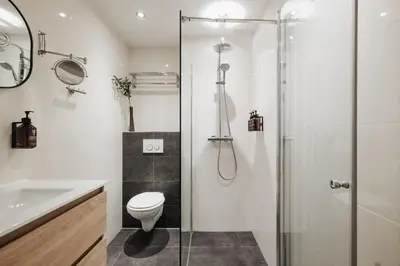 a bathroom with a shower and a toilet and a sink at Adam Suites Hotel in Amsterdam