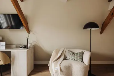 a room with a chair and a desk with a lamp at Adam Suites Hotel in Amsterdam