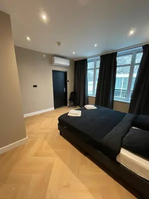 a bedroom with a large bed and a wooden floor at Hotel 83 in Amsterdam
