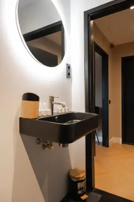 a bathroom with a black sink and a mirror at Hotel 83 in Amsterdam