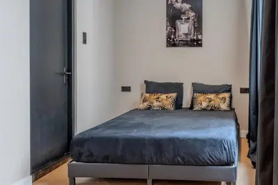 a bedroom with a bed with blue sheets and pillows at Hotel 83 in Amsterdam