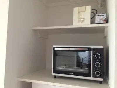 a microwave sitting on a shelf in a kitchen at Apartment Ella with free privat parking in Zandvoort