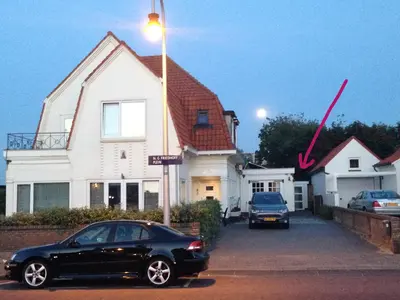 a black car parked in front of a house at Apartment Ella with free privat parking in Zandvoort