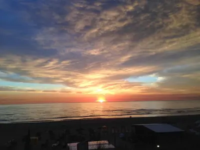 a sunset on the beach with the sun setting at Apartment Ella with free privat parking in Zandvoort