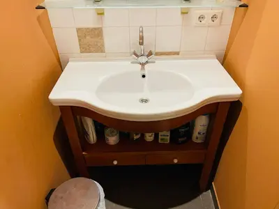 a white sink in a small bathroom at Red light district B & B canal view in Amsterdam