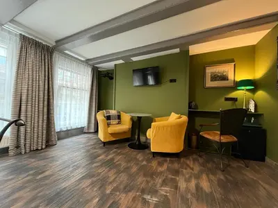 a living room with yellow chairs and a table at Central Guest Rooms in Amsterdam