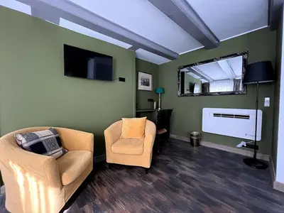 a living room with two chairs and a flat screen tv at Central Guest Rooms in Amsterdam