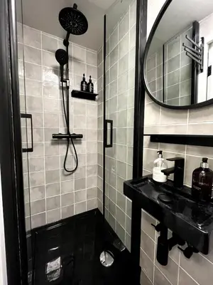 a bathroom with a shower and a sink and a mirror at Central Guest Rooms in Amsterdam
