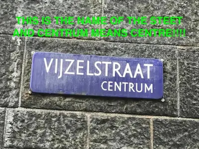 a blue street sign on the side of a brick wall at Central Guest Rooms in Amsterdam