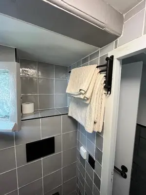 a bathroom with gray tiled walls and towels at Central Guest Rooms in Amsterdam