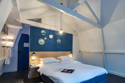 a bedroom with a large bed with a blue wall at Amistad hotel in Amsterdam