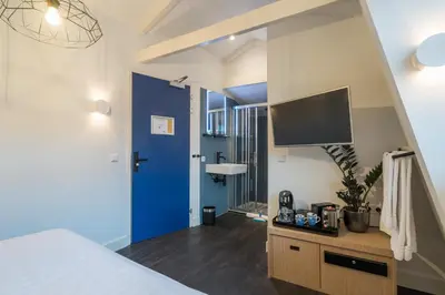 a bedroom with a blue door and a tv at Amistad hotel in Amsterdam