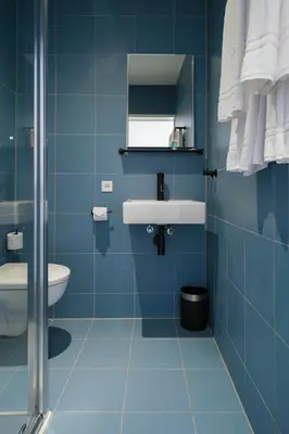 a blue bathroom with a sink and a toilet at Amistad hotel in Amsterdam