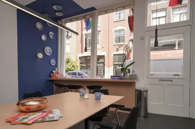 a dining room with a table and a window at Amistad hotel in Amsterdam