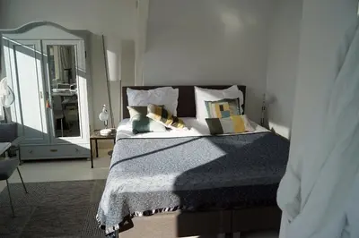 a bedroom with a bed with pillows and a mirror at NR22 Leiden in Leiden