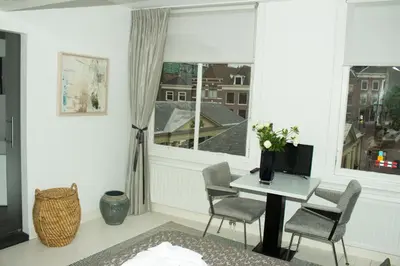 a living room with a table and chairs and a window at NR22 Leiden in Leiden