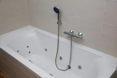 a bath tub with a shower with a shower head at El Puerto Bed and Breakfast in Hoorn