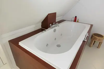 a large white bath tub in a bathroom at El Puerto Bed and Breakfast in Hoorn