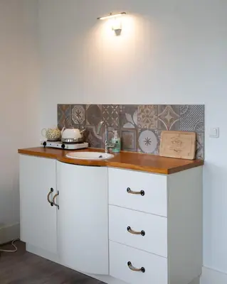 a kitchen with white cabinets and a sink at El Puerto Bed and Breakfast in Hoorn
