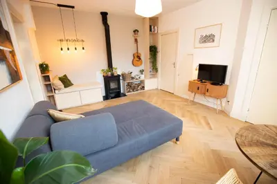 a living room with a blue couch and a table at Cute Beach House Zandvoort in Zandvoort