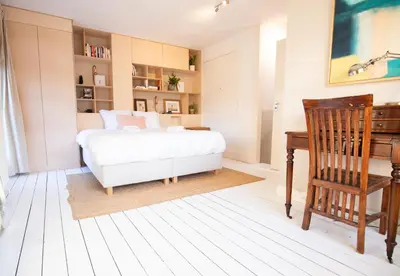 a bedroom with a bed and a desk and a chair at Cute Beach House Zandvoort in Zandvoort