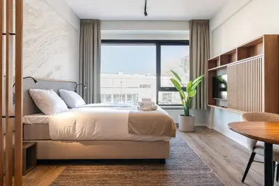 a bedroom with a bed and a large window at Utrecht City Apartments - Huizingalaan in Utrecht