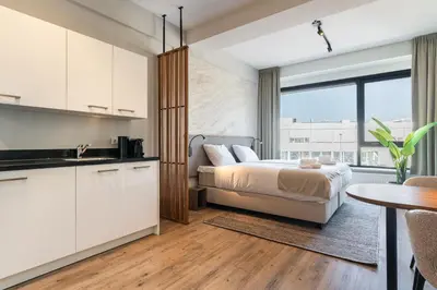 a bedroom with a bed and a kitchen with a table at Utrecht City Apartments - Huizingalaan in Utrecht
