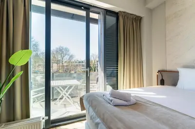 a bedroom with a bed and a large window at Utrecht City Apartments - Huizingalaan in Utrecht