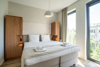 a bedroom with a large bed with towels on it at Utrecht City Apartments - Huizingalaan in Utrecht