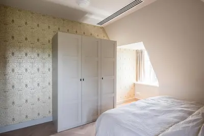 a bedroom with a bed and a white cabinet at De Kievit in Vogelenzang